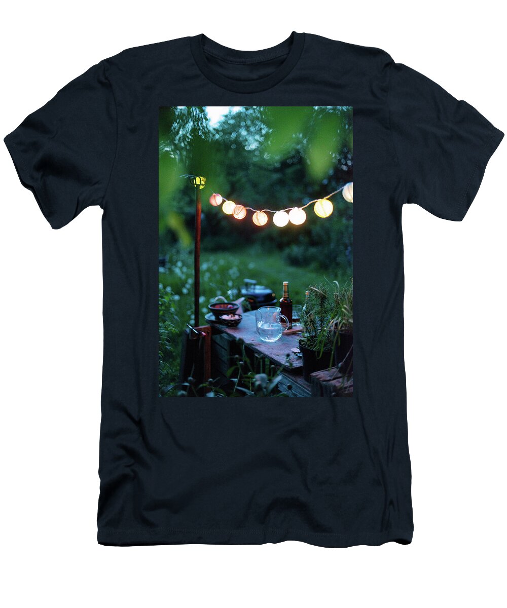A String of Lanterns Above a Rustic Garden Table with Drinks and Snacks Sebastian Schollmeyer T-Shirt