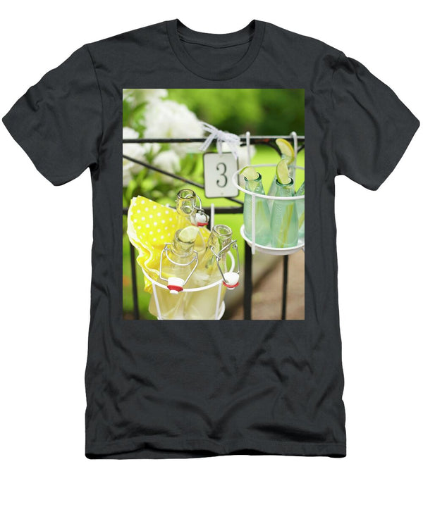Bottles of Lemonade in Wire Basket Hung on Garden Fence Hannah Kompanik T-Shirt