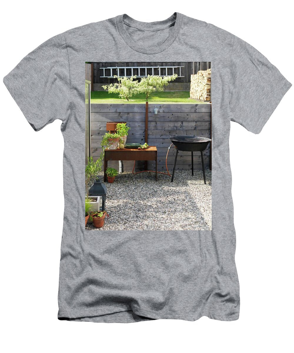 Potted Herbs and Harvested Vegetables on Rusty Metal Side Table Next to Barbecue on Gravel Area in Garden Peter Carlsson T-Shirt