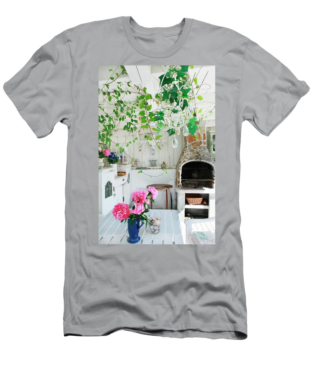 Vase of Pink Peonies on Garden Table in White Wooden Veranda with Fireplace Annette Nordstrom T-Shirt
